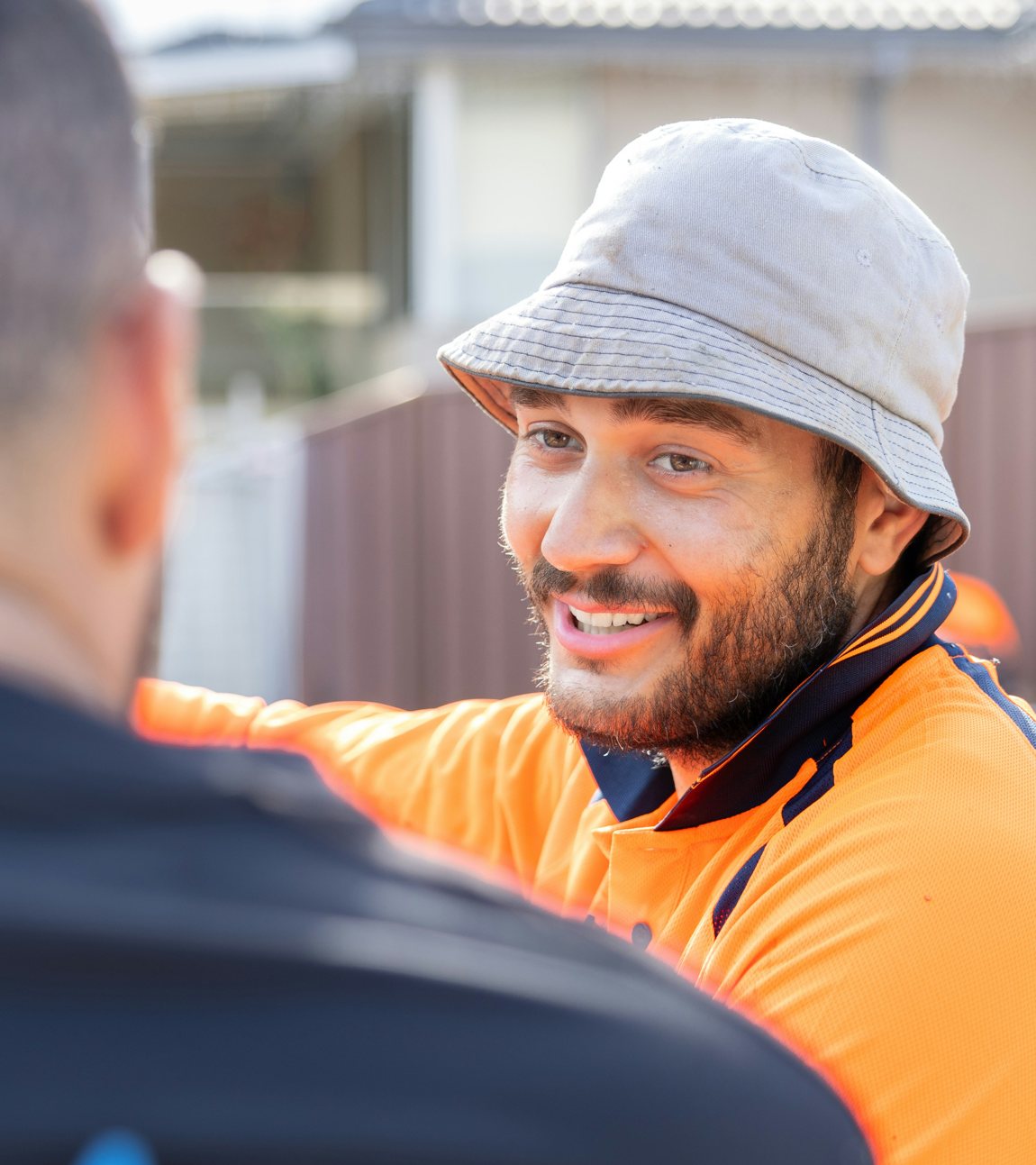 An Australian tradie in hi-vis on site, smiling